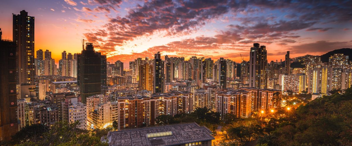 An aerial shot of city skyline under an orange sky at sunset